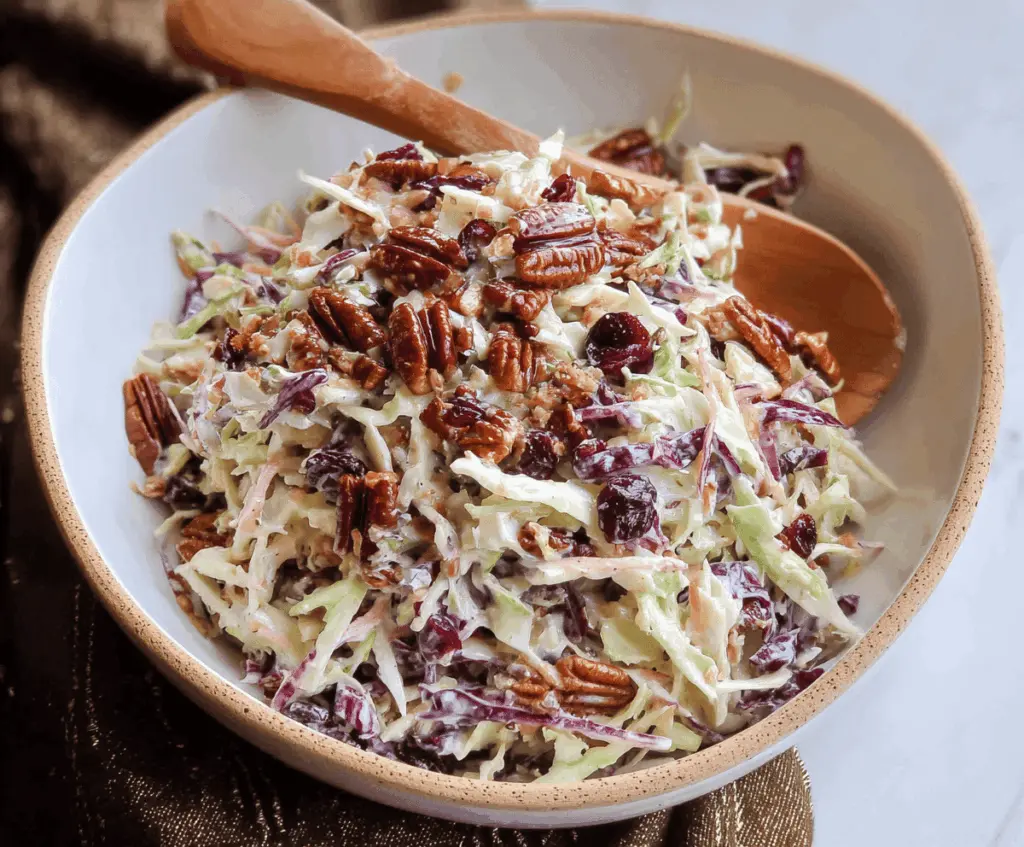 Cranberry Coleslaw with Toasted Pecans in a bowl, featuring vibrant red cranberries, shredded cabbage, and golden toasted pecans for a festive salad