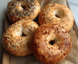 Freshly baked homemade New York bagels on a wire rack, golden brown and chewy.