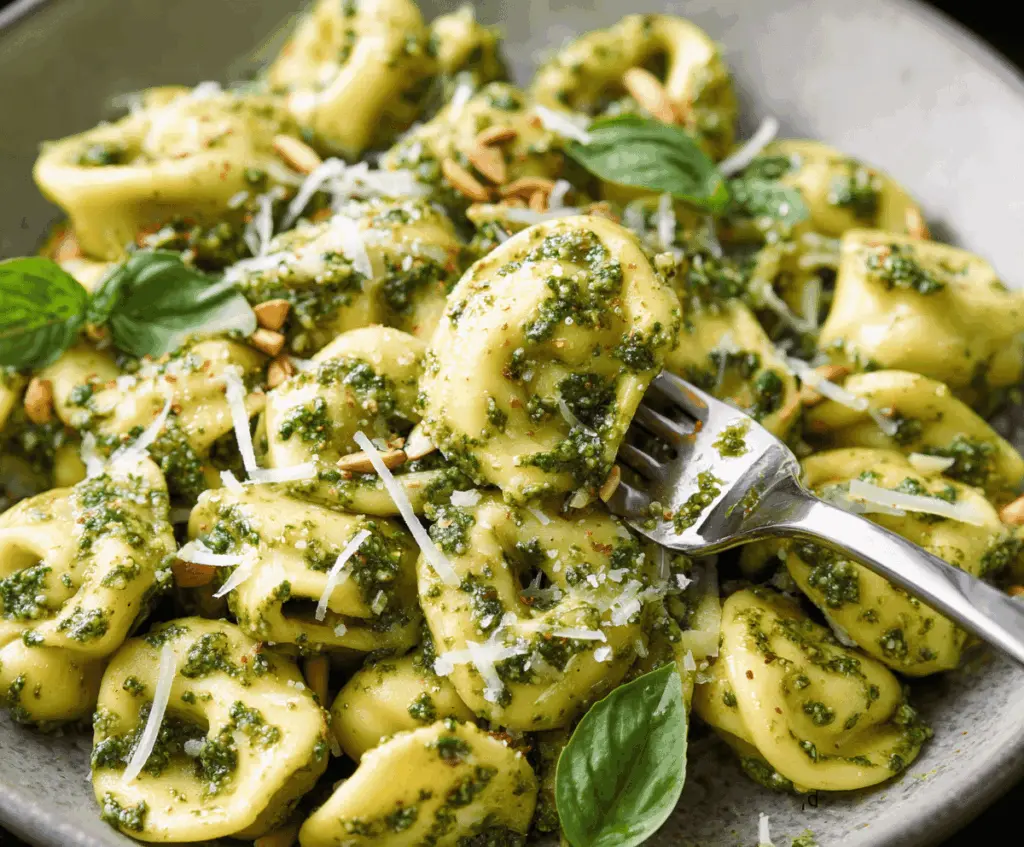 Delicious pesto tortellini served with fresh basil and grated Parmesan cheese