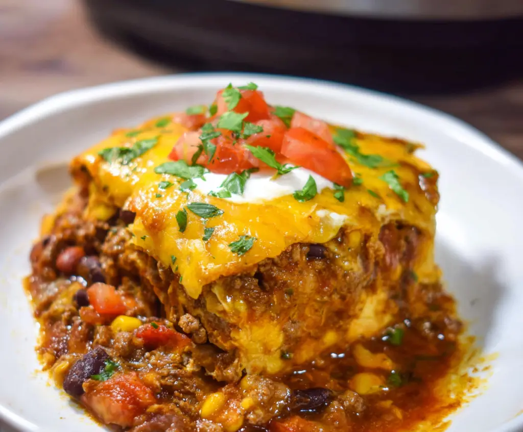 Delicious Crockpot Beef Enchilada Casserole garnished with cheese and fresh herbs in a baking dish.