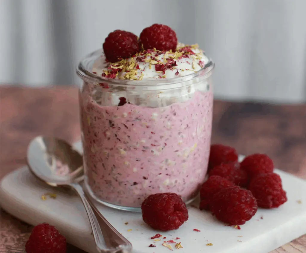 Delicious Raspberry Overnight Oats in a glass jar topped with fresh raspberries and chia seeds.