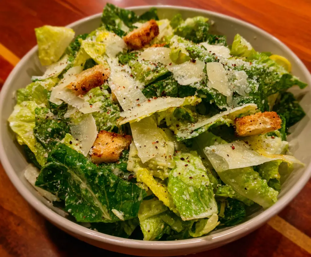 Fresh Nana's Crunchy Lemon Parmesan Salad garnished with lemon slices and parmesan cheese.